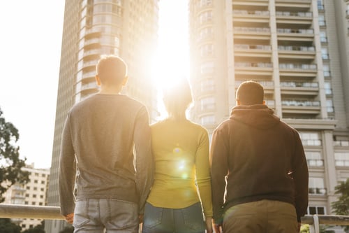Young friends standing looking at sunset
